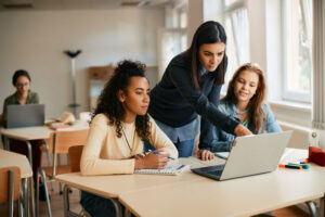 high school esl teacher helping her students