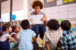 female teacher reading to diverse group of kids