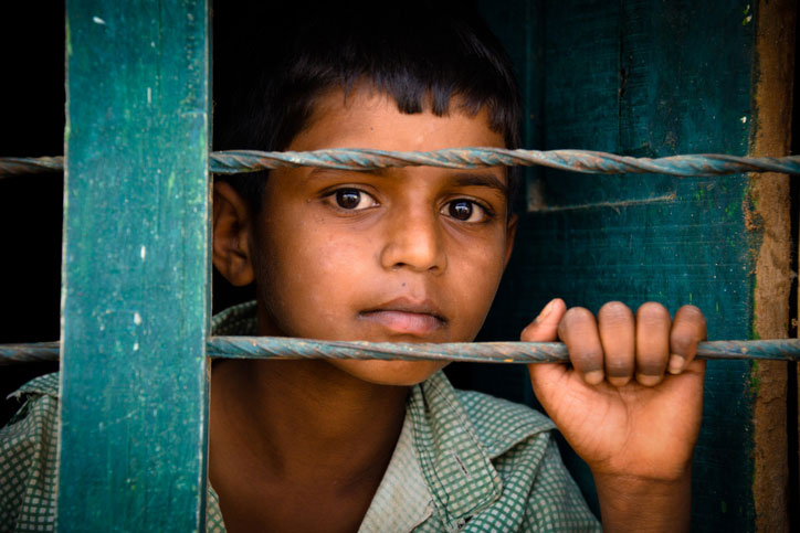 child migrant in camp behind fence